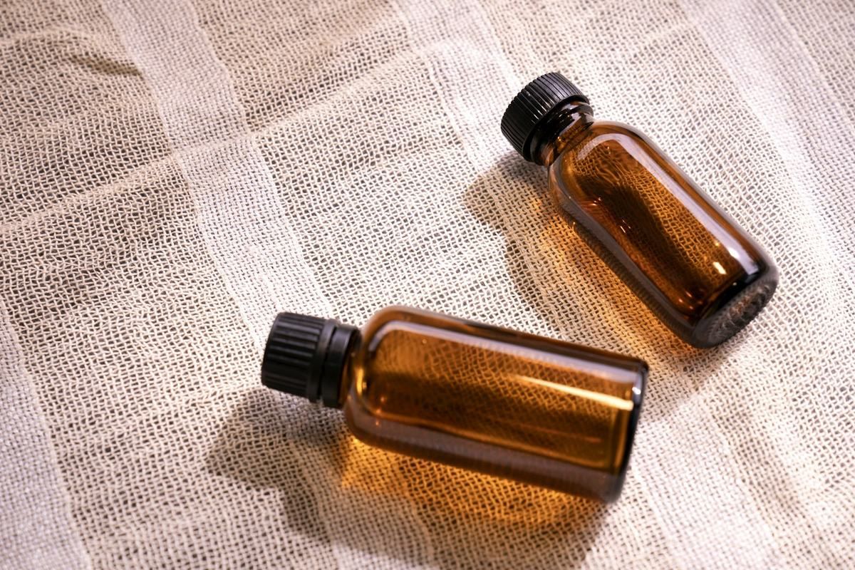 Deux flacons ambrés posés sur un tissu de lin rayé